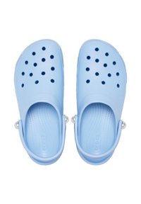 Zoccoli blu chiaro realizzati in materiale morbido e flessibile. Presentano diversi fori per la ventilazione e una cinghia posteriore per una vestibilità sicura. Texture liscia.