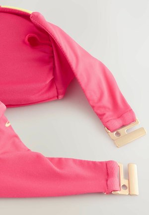 Rosa tyg med mjuk textur; justerbara axelremmar med guldfärgade detaljer; designen har en utskärning fram för extra detaljer.
