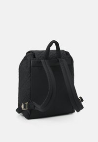 Sac à dos noir matelassé avec une texture en tissu double. Dispose de deux bretelles rembourrées et d'une poignée supérieure. Design simple sans logos ni accents visibles.