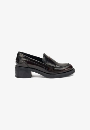 Mocasin de cuero negro pulido con punta redondeada, costuras de contraste y tacón cuadrado. Textura suave y diseño minimalista.
