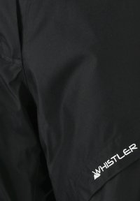 Mustapuku, jossa on sileä kangas ja kiiltävä pinta. Mukana valkoinen "Whistler"-logo ja siisti, minimalistinen muotoilu.