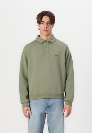 Felpa verde oliva con colletto polo e chiusura a bottoni, con polsini e fondo a costine, e un piccolo logo sul lato sinistro del petto.