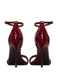 Sandales à talons hauts en cuir verni bordeaux brillant. Design ouvert à l'arrière et aux orteils avec une bride à la cheville au-dessus d'un talon aiguille élancé.