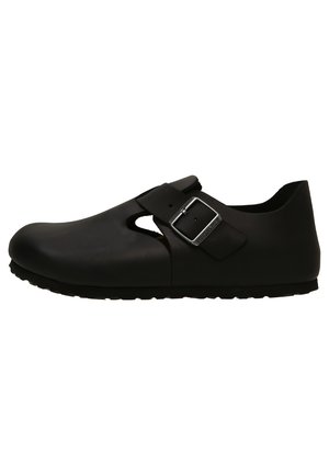 Black, molded clogs with a rounded toe, side cutout, strap with a metallic buckle, and textured rubber sole. Smooth finish.