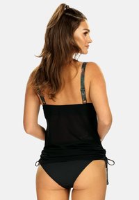 Czarny siatkowy top bez rękawów z regulowanymi, wielokolorowymi ramiączkami. Posiada detal w postaci marszczenia na krawędzi i jest zestawiony z jednolicie czarnym dołem.