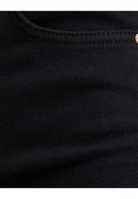 Černá denimová látka s hladkou texturou, obsahující kapsu a jemný lesk. Švy jsou jednotné a těsně upletené.