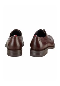 Bruine leren schoenen met ronde neuzen en lage hakken. Voorzien van een gladde textuur en een subtiel driedelig kleuraccent aan de achterkant.