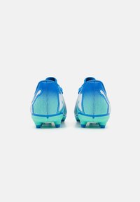 Scarpe da calcio blu con un design a gradiente, caratterizzate da una transizione di colore dal blu chiaro al verde, materiale sintetico testurizzato e tacchetti stampati.