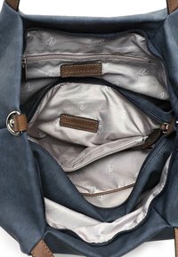 Canvas handbag in navy with smooth brown leather accents. Features multiple zippered compartments and a lined interior with logo pattern.