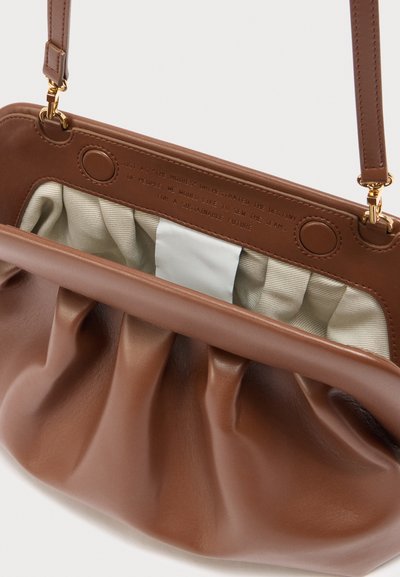 Καφέ δερμάτινη τσάντα ώμου με πτυχωτό σχέδιο, εσωτερική επένδυση από κρεμ ύφασμα και χρυσούς κλειδώματα στα λουριά.