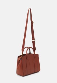 Sac à main en simili cuir marron avec deux poignées et une bandoulière amovible. Présente des coutures verticales et un compartiment zippé. Accents de quincaillerie dorée.