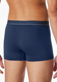 Boxer brev navy blue in tessuto solido, con un design aderente, vita elasticizzata e un bordo a contrasto in vita.