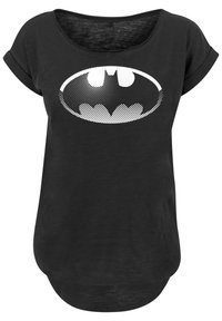Svart t-skjorte med avslappet passform og rullede ermer, med en stor hvit prikkete Batman-logo på fronten. Myk tekstur.