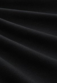 Tela negra con una textura suave, que presenta pliegues suaves y un acabado mate. No se observan patrones ni acentos.