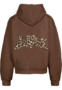Brun cropped hettegenser med teksturert stoff. Har et leopardmønster i krem og svart på baksiden, som skaper en kontrasterende effekt.
