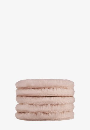 Tissu en fausse fourrure rose pâle, doux et plié, empilé uniformément sur un fond blanc uni.