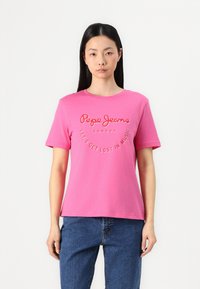 Rosa bomull t-shirt med korta ärmar, rund halsringning och tryckt text: "Pepe Jeans London Låt oss gå vilse i musiken." Avslappnad passform.