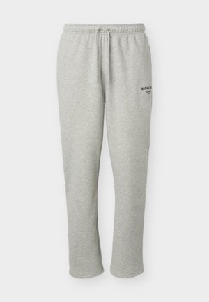 Lysegrå joggebukser med elastisk midjebånd og snor, rette bein, lite svart trykt logo på øvre venstre lår.