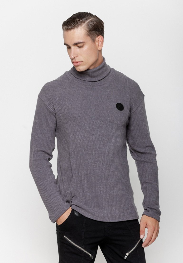 Szary prążkowany sweter z golfem, z długimi rękawami, z okrągłym czarnym logo na klatce piersiowej i fakturowanym wzorem tkaniny.