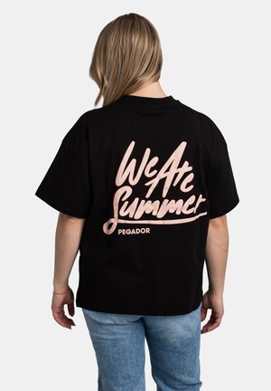 Zwart katoenen t-shirt met korte mouwen en een losse fit. Voorzien van roze cursieve tekst "We Are Summer" en "PEGADOR" op de rug.