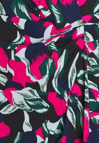 Rohkea kukkakuosi vaaleanpunaisilla, vihreillä ja laivaston sinisillä sävyillä mustalla kankaalla, jossa on päällekkäisiä lehtiä ja abstrakteja muotoja.