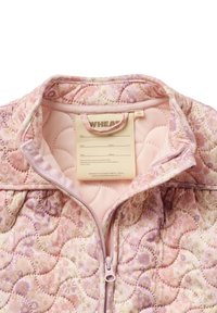 Veste matelassée rose rembourrée avec motif floral, fermeture éclair intérieure et étiquette pour le nom et la taille. Texture douce avec des détails de couture courbés.