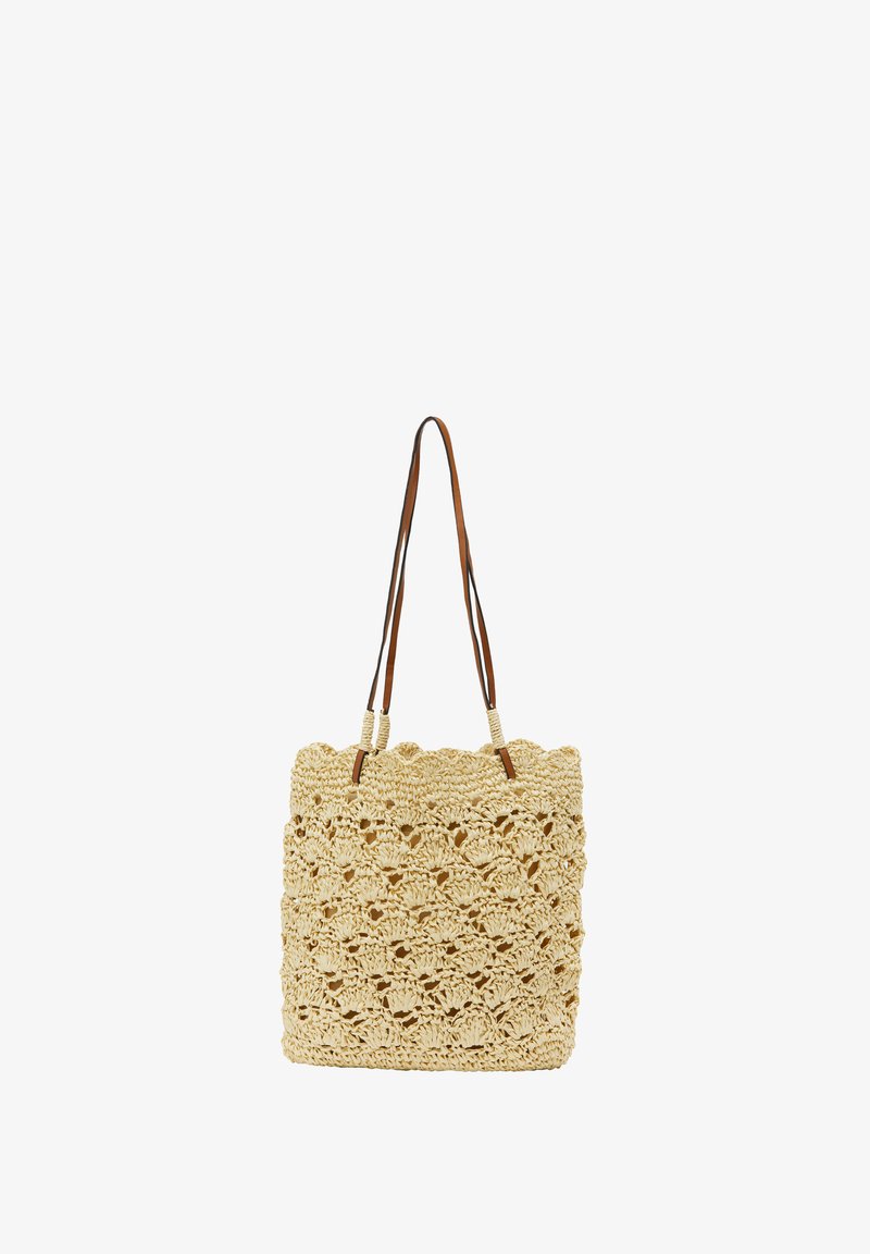 Torba z plecionej słomy w odcieniu beżowym o teksturowanym, ażurowym wzorze. Posiada dwa brązowe skórzane uchwyty oraz kwadratowy kształt.