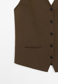 Gilet marrone lavorato a maglia con scollo a V, sei bottoni neri e una sola tasca laterale. Texture liscia, design aderente e forma affusolata.