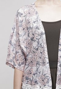 Leichter floralem Kimono mit kurzen Ärmeln, der große rosa und graue Blumen auf einem transparenten Hintergrund zeigt. Spitzenbesatz am Saum.