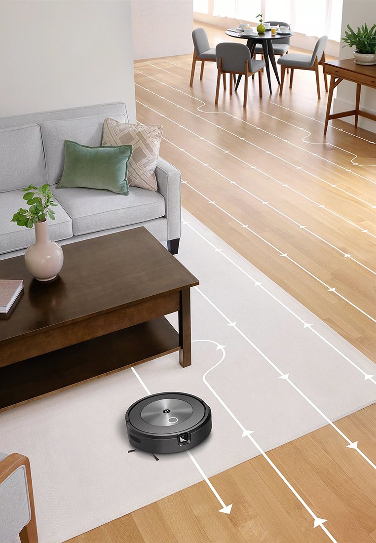 Ein Robotersauger reinigt ein Wohnzimmer mit Holzböden, während weiße Pfeile seinen Reinigungsweg in der Nähe eines Couchtisches und einer Couch anzeigen.