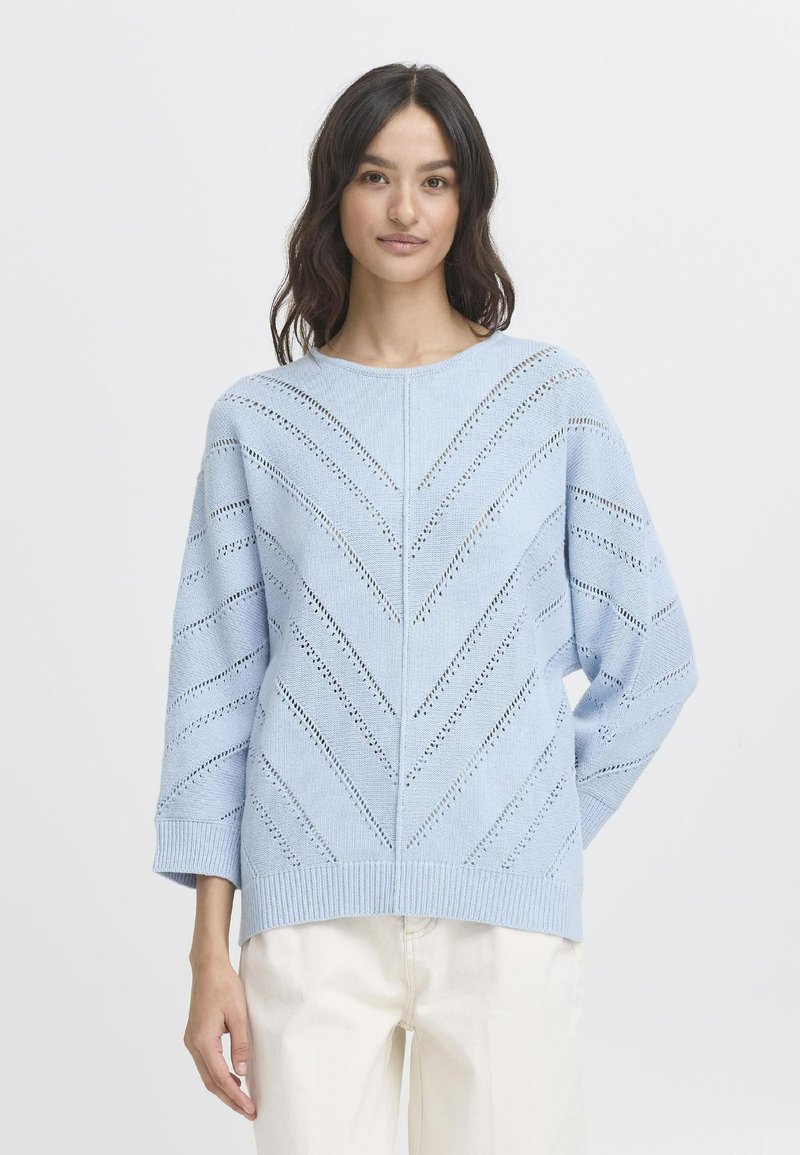 Helltürkis gestrickter Pullover mit Chevron-Spitzenmuster, rundem Ausschnitt und überschnittenen Schultern. Gerippter Saum und Bündchen. Klassische Passform.