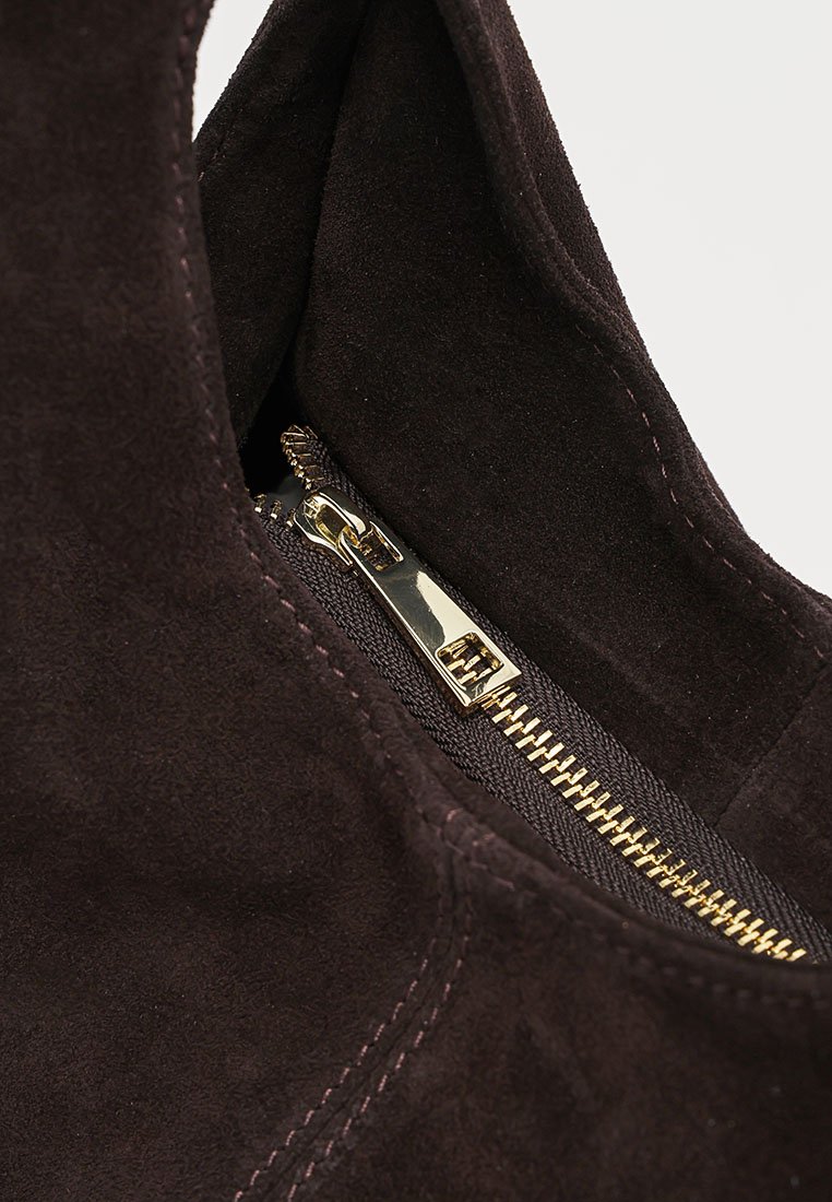 Primer plano de una bota de ante marrón oscuro con una cremallera dorada brillante parcialmente abierta y detalles de costura visibles.