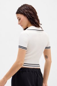 Polo alb cu dungi ribbate, cu mâneci scurte, dungi negre pe guler și mansete, design slim-fit și material texturat.