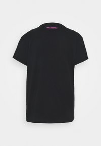 Svart bomull t-shirt med rund hals och korta ärmar. Har rosa "KARL LAGERFELD" text på övre ryggen. Enkel design.