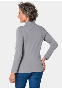 Grijze longsleeve top met een hoge kraag, een gladde textuur en een getailleerd ontwerp. De achterkant toont subtiele stiksels en een ronde zoom.