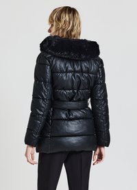 Giacca imbottita nera con colletto in pelliccia sintetica, vita con cintura, design imbottito e maniche lunghe. Texture liscia con segmenti trapuntati visibili.