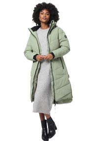 Long, light green puffer coat with a hood, zippered front, and quilted pattern. Worn over a gray dress and paired with black ankle boots.