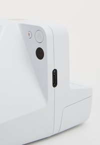 White compact device with a textured surface, power and charging buttons, a digital display, and a USB-C port on the side.
