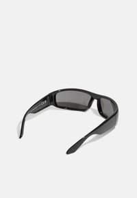 Lunettes de soleil noires avec des verres rectangulaires. Monture en plastique brillant, temples légèrement courbés et verres teintés foncés pour protection UV.