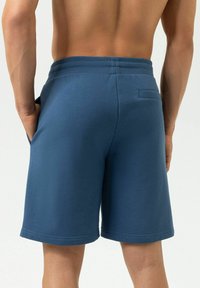 Blauwe sweatshorts met een elastische tailleband, zijzakken en een achterzak. Gemaakt van zachte stof met een gladde textuur.