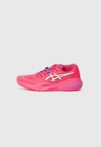 Chaussure de sport en rose vif, présentant une texture en maille, un design minimaliste, des accents blancs et des lacets bleus. Semelle courbée avec une forme aérodynamique.