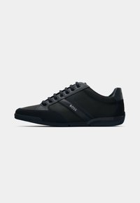 Black sporty shoes with a mix of smooth and textured materials, featuring round laces, a logo accent on the side, and a curved sole design.