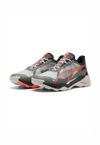Grijze sportieve schoenen met zwarte en koraal accenten, voorzien van een gestructureerd mesh bovenwerk, veters en een chunky witte en zwarte zool voor grip.