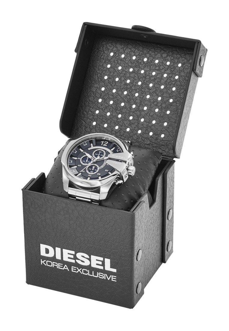 Reloj cronógrafo Diesel para hombres en plata con esfera negra, descansando sobre un cojín negro dentro de una caja negra texturizada abierta etiquetada como "Diesel Korea Exclusive".
