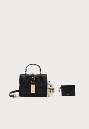 Borsa a tracolla nera trapuntata con chiusura in catena dorata, con un piccolo orsetto bianco con fiocco marrone attaccato, e portacarte nero coordinato con logo dorato.