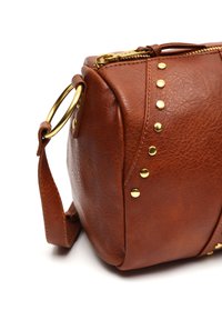 Borsa in pelle marrone con texture e hardware dorato, dotata di chiusura a zip e borchie decorative sui lati. Cinghia regolabile inclusa.