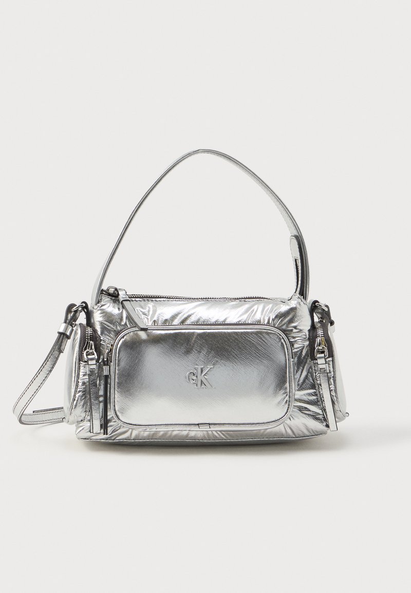 Metallic silver handbag with a rectangular shape, top zipper, and front pocket. Features a short handle and adjustable strap. Textured finish.