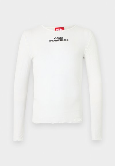 Balta ilga rankovėmis marškiniai iš minkštos medžiagos, su apvaliu kaklu, juodu siuvinėjimu "032c WORKSHOP" ir mažuoju logotipo akcentu apatinėje dalyje.