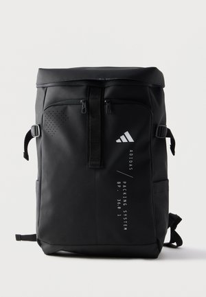 Schwarzer adidas rechteckiger Rucksack mit Rolltop-Verschluss, vorderen Reißverschlusstaschen, seitlichen Schnallen und vertikalem weißem Logo und Schriftzug auf der Vorderseite.