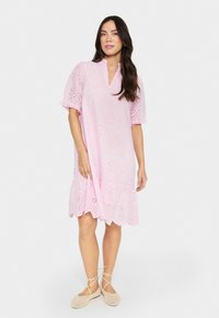 Robe en coton rose clair avec un ourlet festonné, des manches bouffantes courtes et des détails en oeillets tout au long pour un effet de texture supplémentaire.